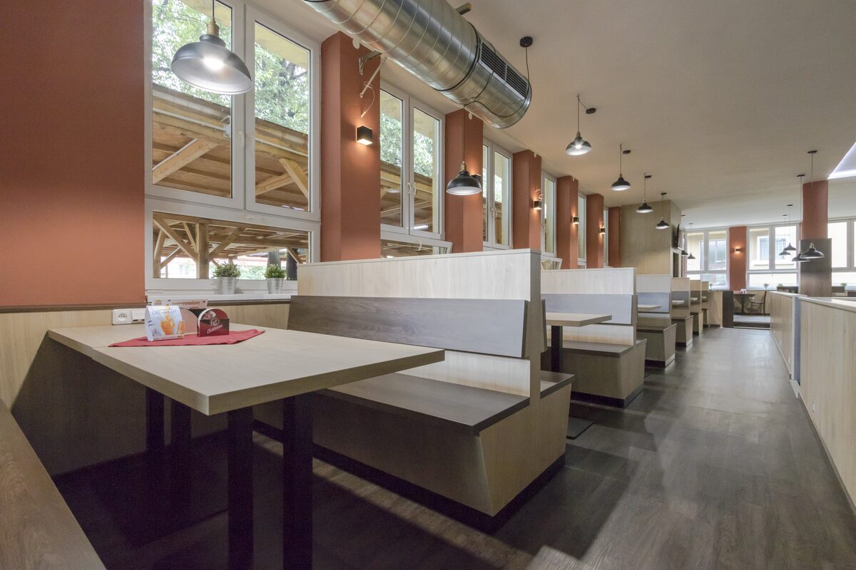 Interiér restaurace Na Sídlišti 1962 — boxy a dřevěné stoly